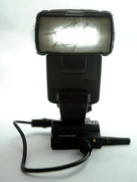 The Canon 550EX firing at low power. You can see silohette of the broken front element that I glued back together a long time ago.